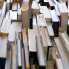 Someone's hand selecting a book from a large selec